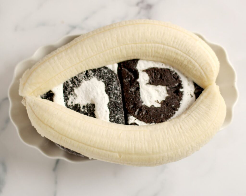 2 slices of a chocolate cake roll with a 2 banana halves on top in a dish
