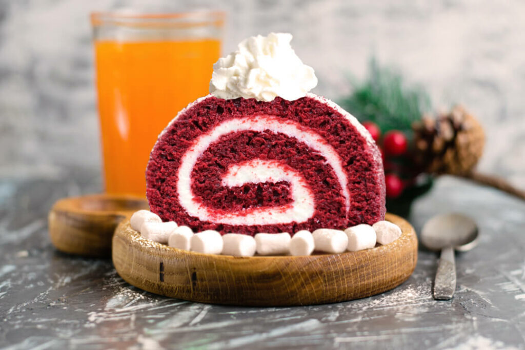 Decorated red velvet cake roll slice on table. Menu tips for winter party