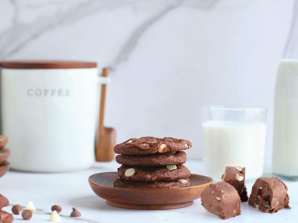 Triple Chocolate cookies with Raw Cookie Dough on marble background with kitchen items