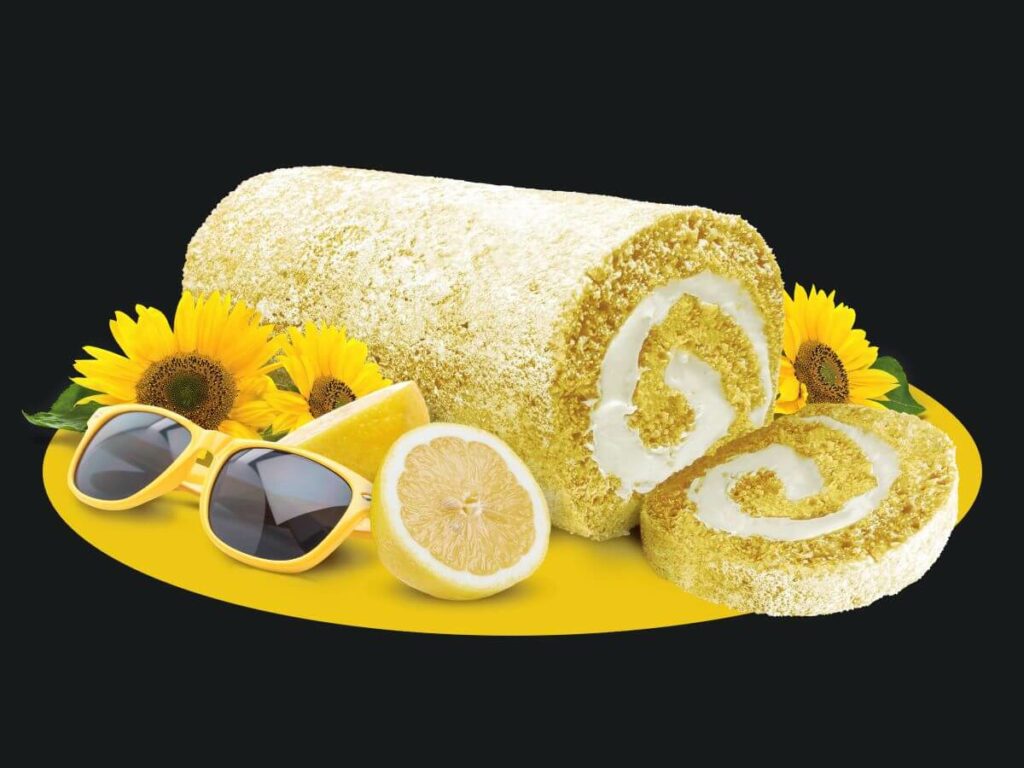 Dutch Apron Bakery Lemon Creme Cake Roll with sunflowers, yellow sunglasses, and lemons