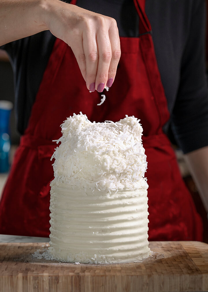 Sprinkled coconut flakes on head of polar bear cake roll