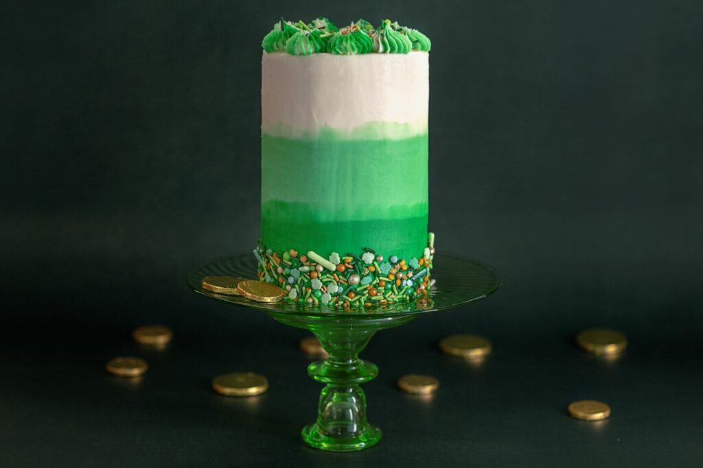 Mint Chocolate Ombre Cake Roll on green cake stand surrounded by chocolate coins
