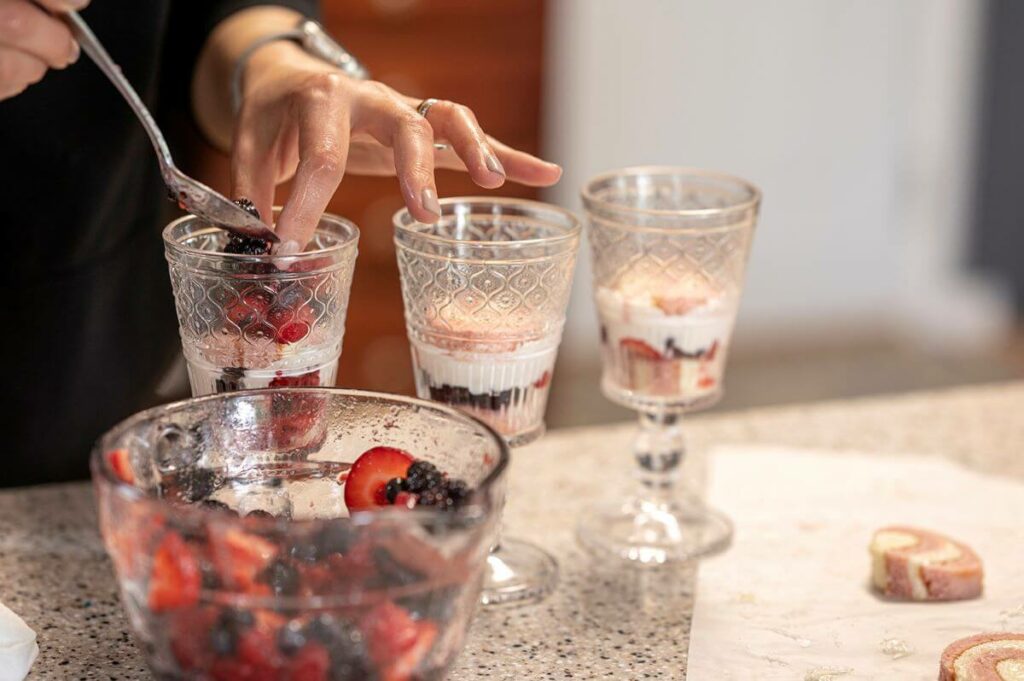 Layering the berries into the glasses to make the Mixed Berry Shortcakes
