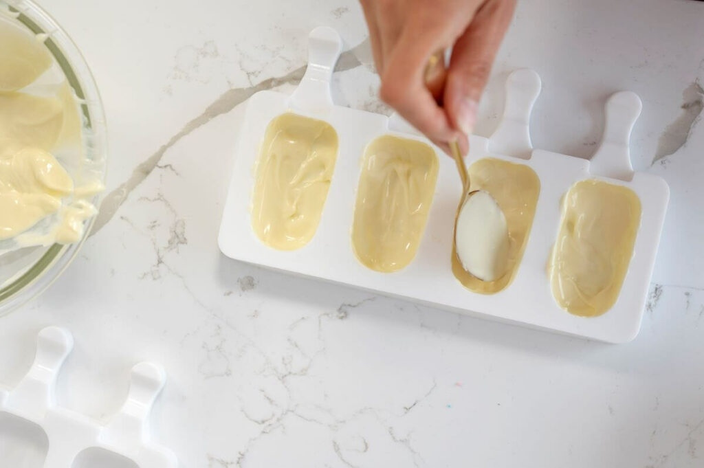 Creating the outer shell of the cakesicle with the white chocolate