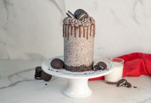 Cookies and Cream Cake Roll with milk, sandwich cookies, and a red napkin in the background.