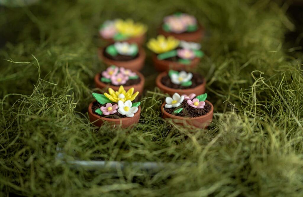 Flowerpot Cakes on a bed of fake grass. The first two are in focus, the rest are blurred out in the background.