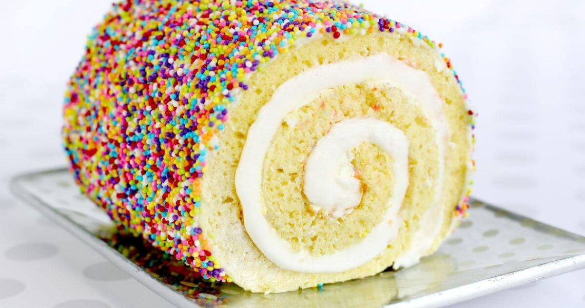 Sprinkle Cake Roll - lemon cake roll on metal serving tray, covered in sprinkles